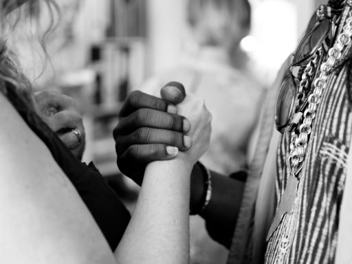 grayscale photo of man and woman holding their hands